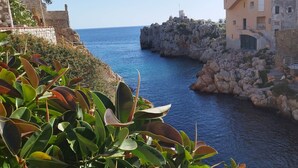 A coastal view with rocky cliffs and a narrow waterway. - Stunning apartment only 100 meters from the sea and spectacular gulf view. (Santa Flavia)