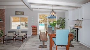 A spacious kitchen with white cabinets, a wooden dining table, and blue chairs. - Fallbrooks Finest Hideaway Villa - Pool, Game Room (Fallbrook)