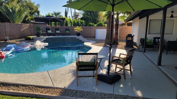 A backyard with a swimming pool, lounge chairs, and a patio area. - North Phoenix Beautiful Home. Huge Pool. Same events okay. (Phoenix)