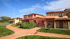 A residential complex with multiple houses featuring terracotta roofs and stucco walls. - Apartment in Vignola Mare near Sandy Beach (Vignola Mare/Aglientu (SS))
