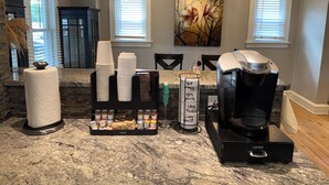 Une cuisine équipée d’une machine à café Keurig, d’un distributeur d’essuie-tout et d’un porte-tasse.