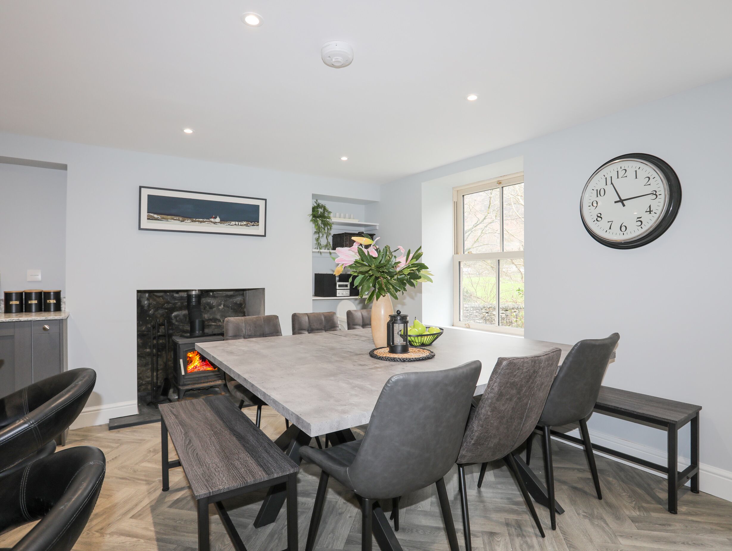 A modern dining area with a large table, chairs, and a fireplace.