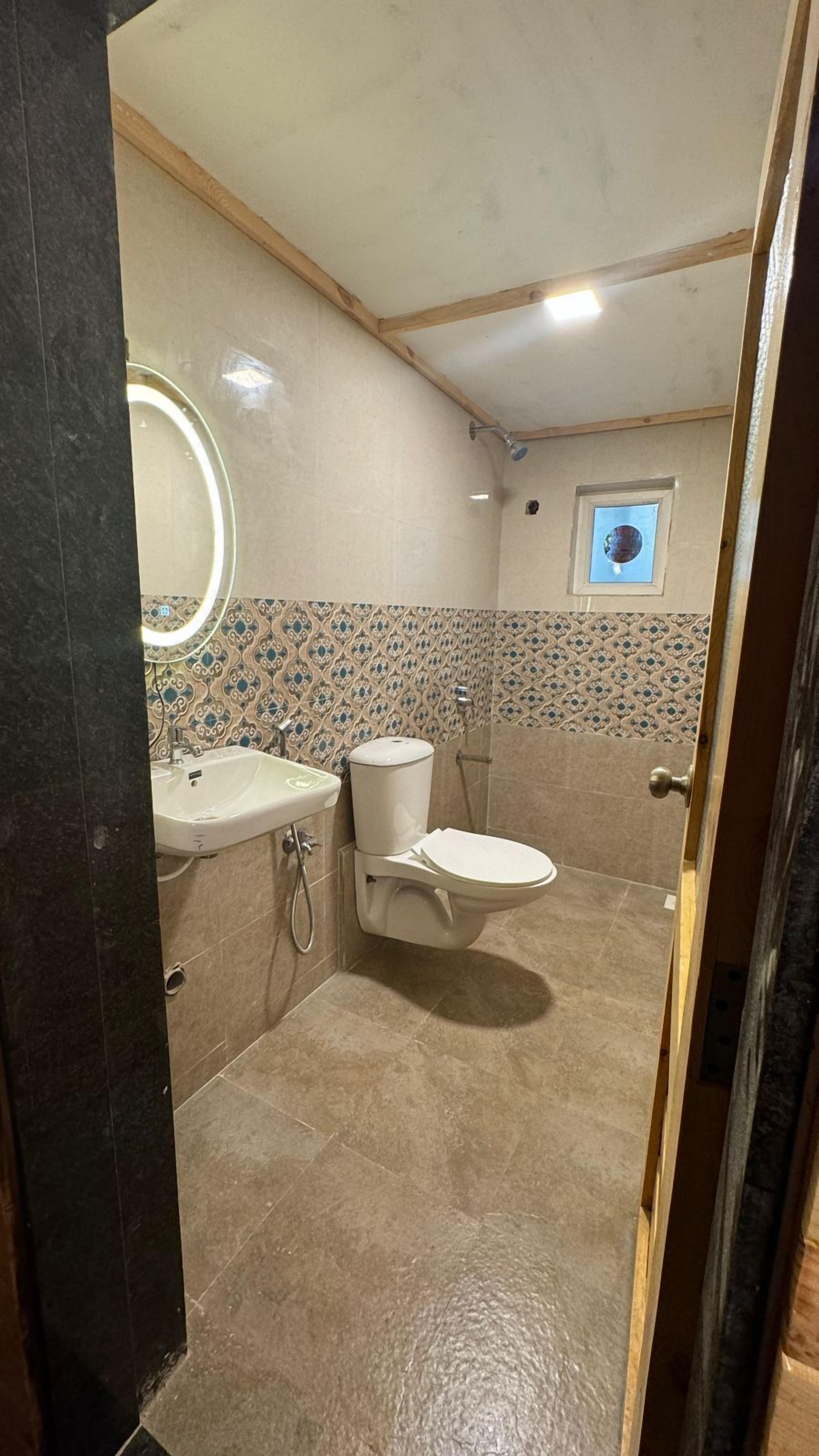 A bathroom with a toilet, sink, and shower.