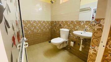 A bathroom with a toilet, sink, and shower.