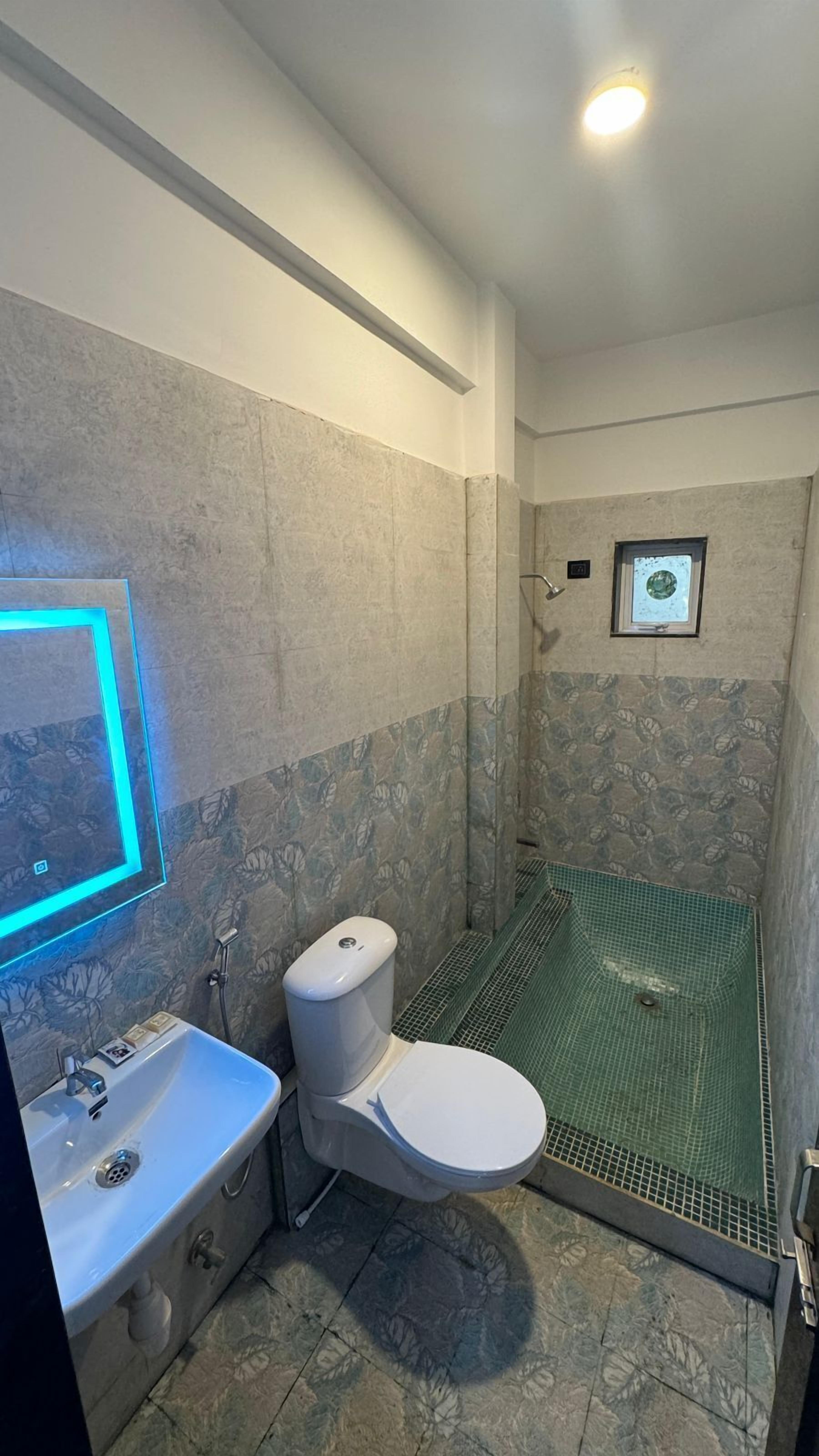 Ein Badezimmer mit Dusche, Toilette und Waschbecken.