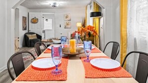 A dining area with a long table set for four, featuring red placemats and clear glassware. - Jax Bch Home 3/2 w/Pets (Jacksonville Beach)