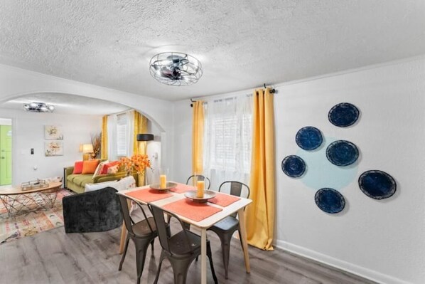Un espace repas comprenant une table, des chaises et un ventilateur de plafond.