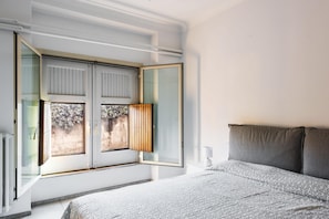 A bedroom with a large bed, a window with blinds, and a view of the outdoors. - Euphorbia Apartment 2 in Catania by Wonderful Italy (Catania)