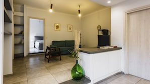 A modern kitchen with a built-in island, a dining area with a green sofa, and a staircase leading to an upper level. - Euphorbia Apartment 2 in Catania by Wonderful Italy (Catania)
