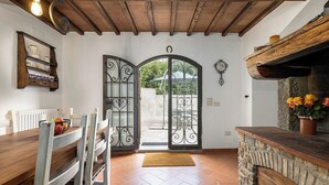 A kitchen with a wooden table, chairs, a stone counter, and a potted plant. - Chianti Villa Chicco, private swimming pool with large garden, bbq, car parking (Province of Florence)