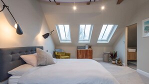 A bedroom with a large bed, a headboard, a desk, a chair, and skylights. - 2 Bedroom Apartment - 200m From Richmond Park (Kingston Upon Thames)