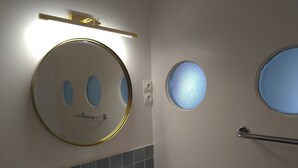 A bathroom with a round mirror, a sink, and a handrail. - Dinard Hyper Centre 400m Plages Beau Studio Wifi (Dinard)