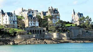 A coastal castle with multiple buildings, a stone bridge, and a clear view of the sea. - Dinard Hyper Centre 400m Plages Beau Studio Wifi (Dinard)