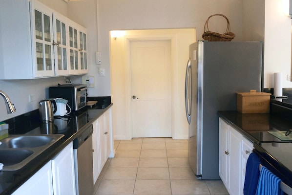 A kitchen with a refrigerator, a toaster, and cabinets.