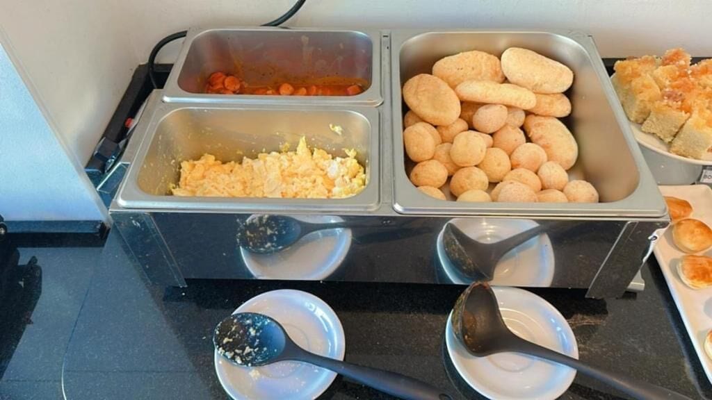 Een ontbijtbuffet met diverse gerechten, zoals roerei, worst en broodjes.
