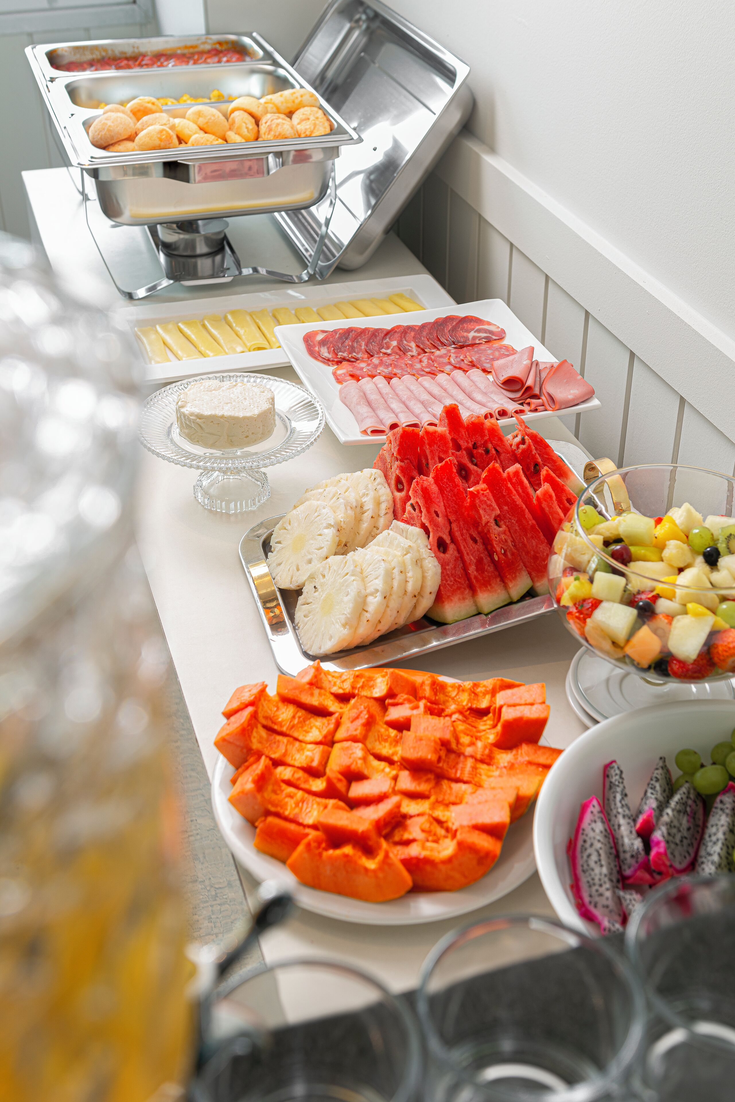 A buffet with various food items including fruits, vegetables, and meats.