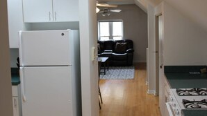 Una cocina compacta con refrigerador, estufa y un comedor con mesa y sillas.