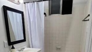 Een kleine badkamer met toilet, wastafel en bad.