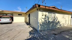 A single-story building with a garage, a parked car, and a fenced area. - 2 bedroom 1 bathroom, Cozy home (South El Monte)