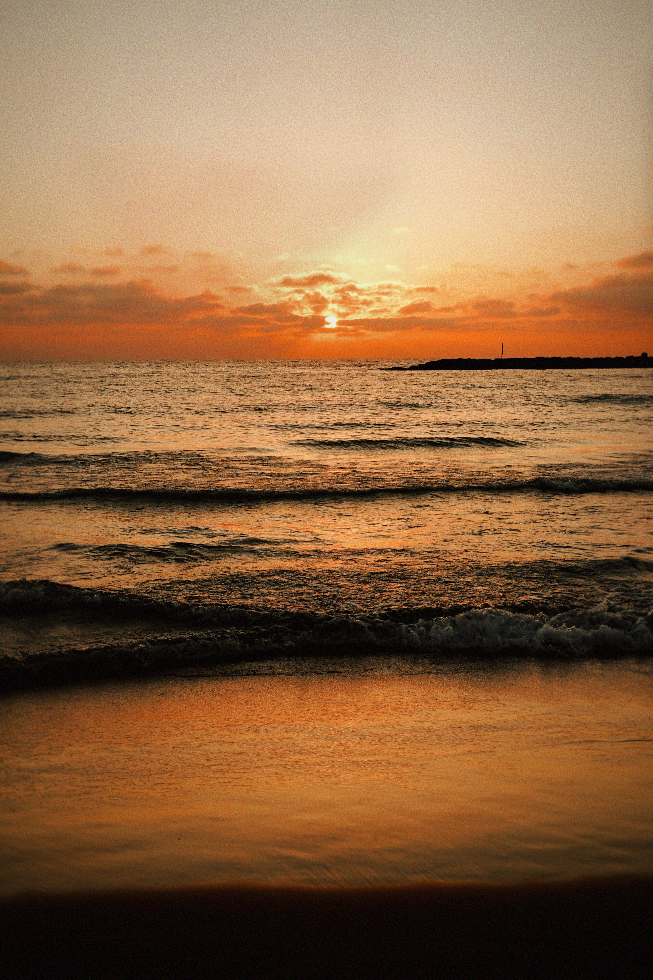 Un atardecer sobre el océano con olas.