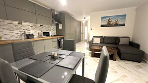 Eine moderne Küche mit Essbereich, einer Couch und einem Bild an der Wand.