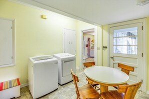 A laundry room with two washing machines, a table, and chairs. - Central & Ornate Sewanee Home w/ Screened-In Porch (Sewanee)