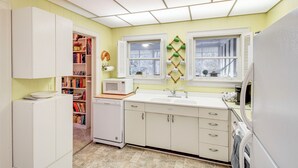A compact kitchen with white cabinets, a microwave, and a sink. - Central & Ornate Sewanee Home w/ Screened-In Porch (Sewanee)