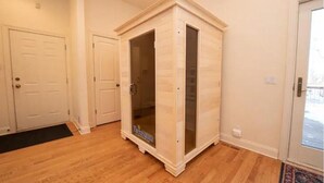 A room with a wooden floor, a white door, and a glass door with a logo. - Peaceful Retreat (Minneapolis)