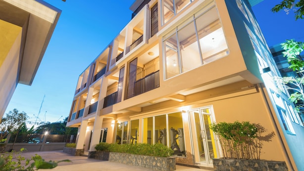 A multi-story hotel with a modern design, featuring balconies, large windows, and a well-lit entrance.
