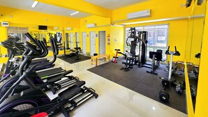 A gym with treadmills, weight machines, and a mirrored wall.