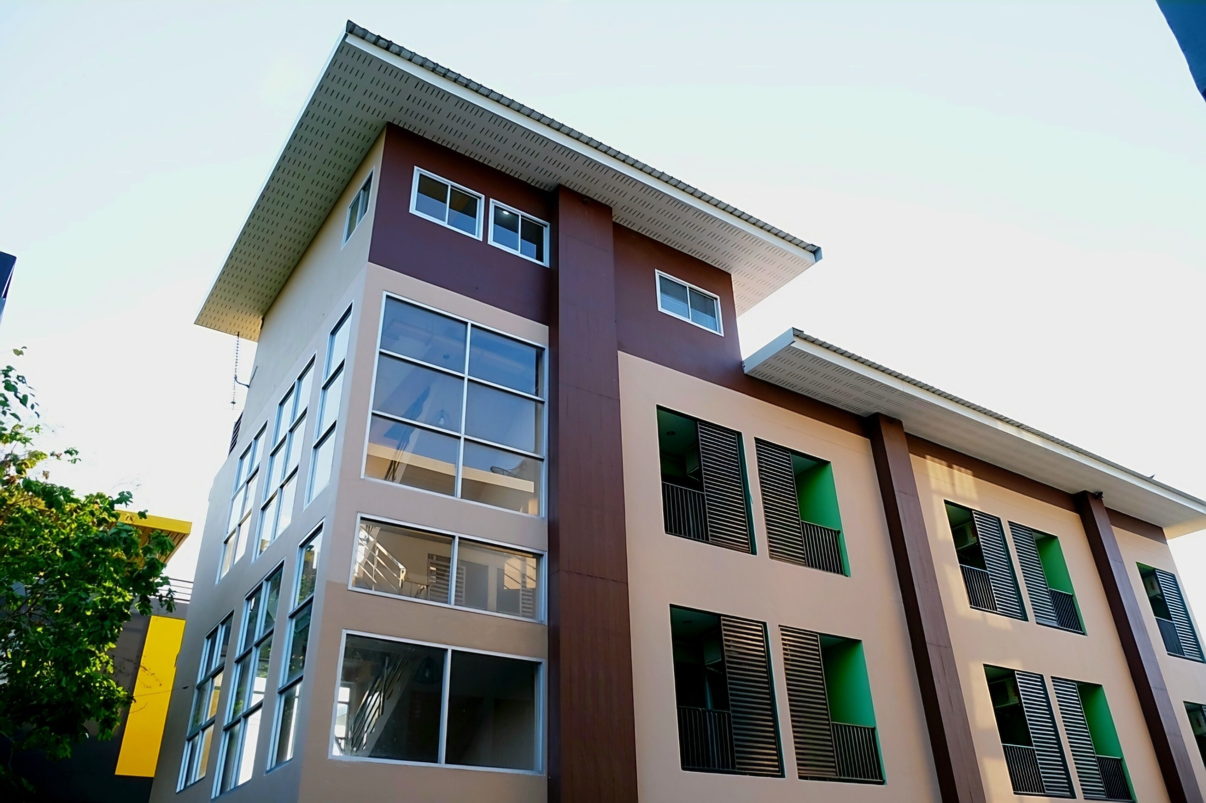 Un edificio de varios pisos con un diseño arquitectónico moderno, que cuenta con amplios ventanales y un techo plano.