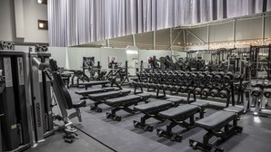 A gym with multiple benches, dumbbells, and weight machines. - Playhotel (Mjolby)