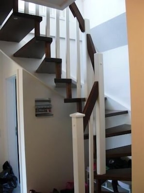 Eine Treppe mit Holzbodenstufen und weißen Spindeln.