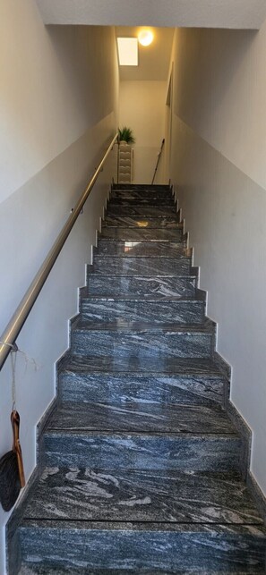 A staircase with a handrail and a broom leaning against the wall. - Strandkrabbe: Your vacation by the sea! (Borkum)