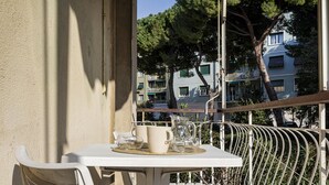 A balcony with a table set for two, overlooking a residential area with trees and buildings. - La Maison in Albaro by Wonderful Italy (Genoa)