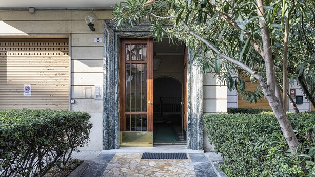 A building entrance with a wooden door, stone steps, and a small garden area. - La Maison in Albaro by Wonderful Italy (Genoa)