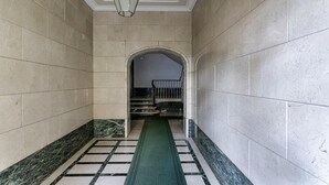 A hallway with marble walls, a green carpet, and a staircase leading to an upper level. - La Maison in Albaro by Wonderful Italy (Genoa)