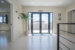 A spacious room with a large sliding glass door leading to a balcony.