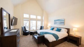 A bedroom with a large bed, a desk with a chair, a dresser, and a TV. - Secluded Spa-cious Retreat -Beds for 8. Plus 3 foldaways extra (Minneapolis)