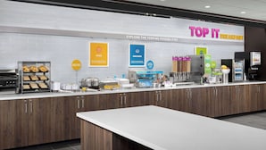 A breakfast area with a sign reading "TOP IT BREAKFAST" and various food options like eggs and pancakes. - Tru By Hilton Columbus East Broad (Columbus)