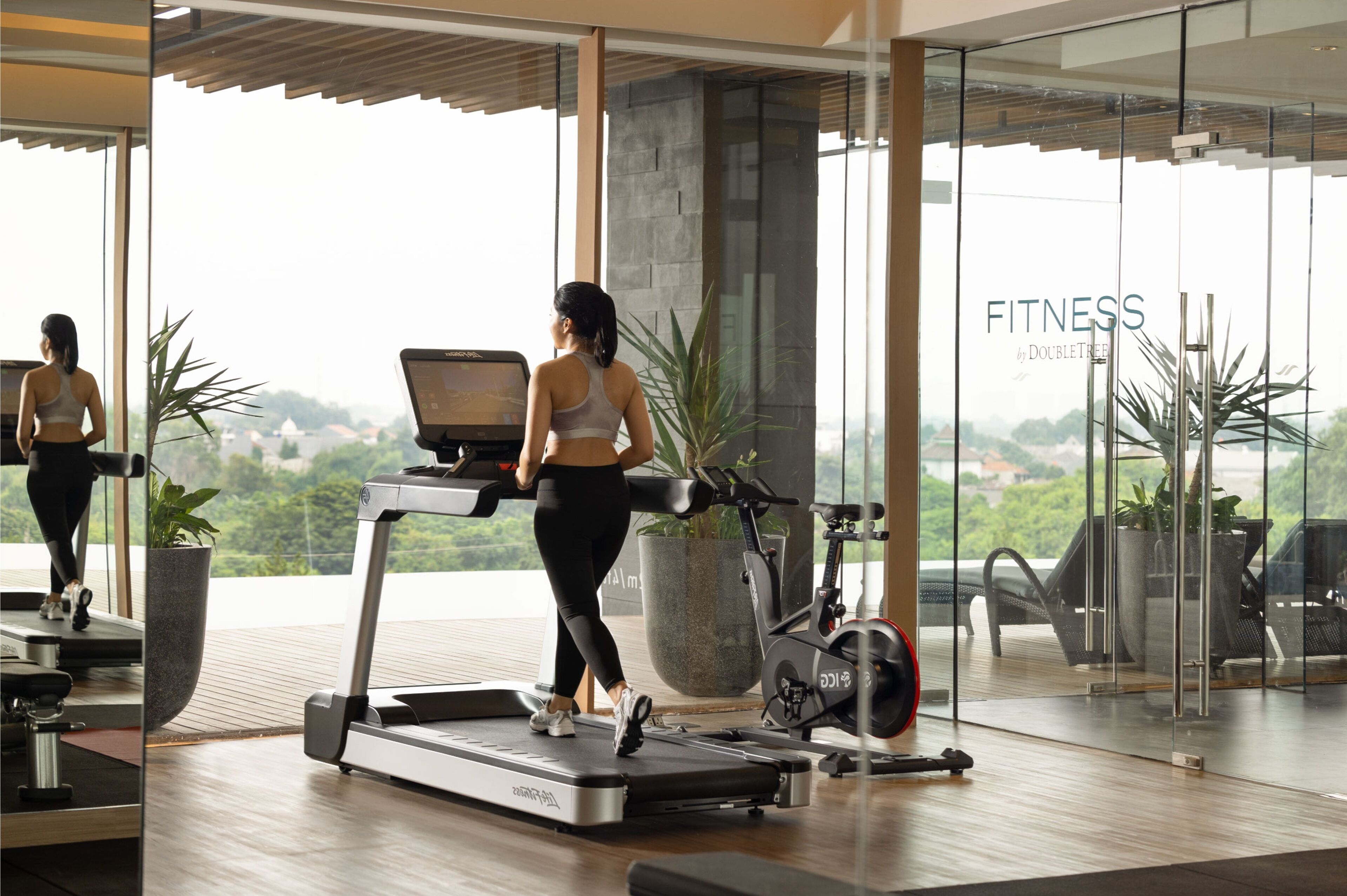 A modern fitness center with a treadmill, stationary bike, and exercise equipment.
