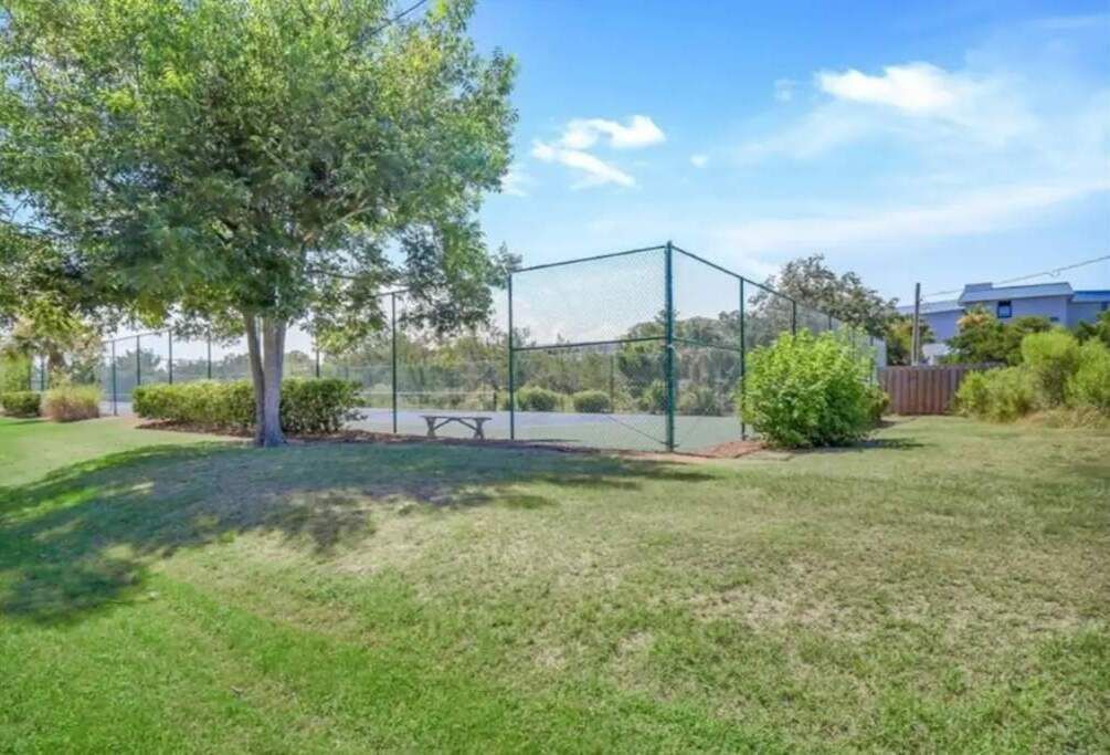 Espacio al aire libre cercado con una mesa de picnic y un árbol.