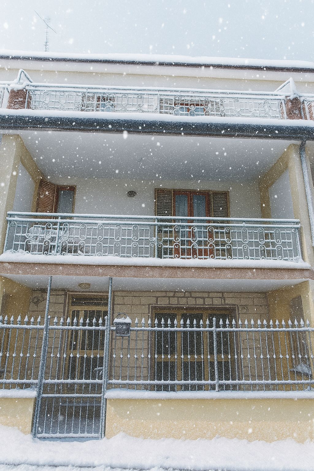 A two-story building with a balcony and a metal fence.