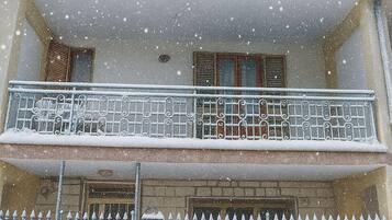 A two-story building with a balcony and a metal fence.