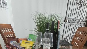 Une table à manger dressée avec un menu, des verres à vin, une bouteille et des amuse-gueules.