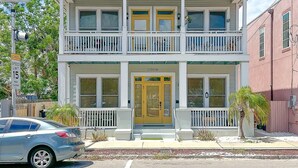 A two-story building with a front porch, a garage, and a mailbox.
