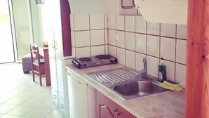 A compact kitchen with a sink, a stove, and cabinets. - Villa Thomas Nakas (Parga)