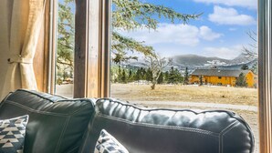 Una habitación con vista a un edificio amarillo y montañas.