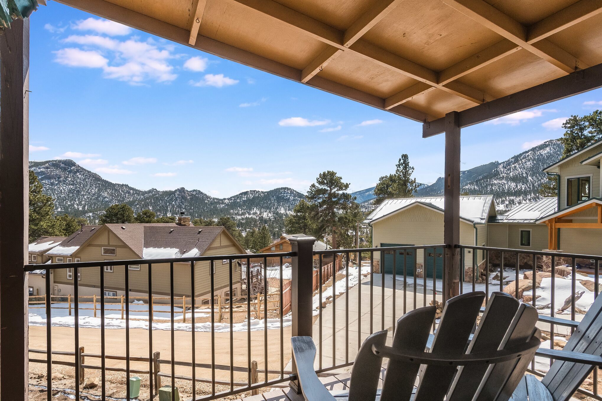 A balcony with a view of a residential area and mountains.