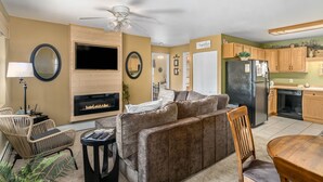 A living room with a fireplace, a sofa, a coffee table, and a dining table with chairs.